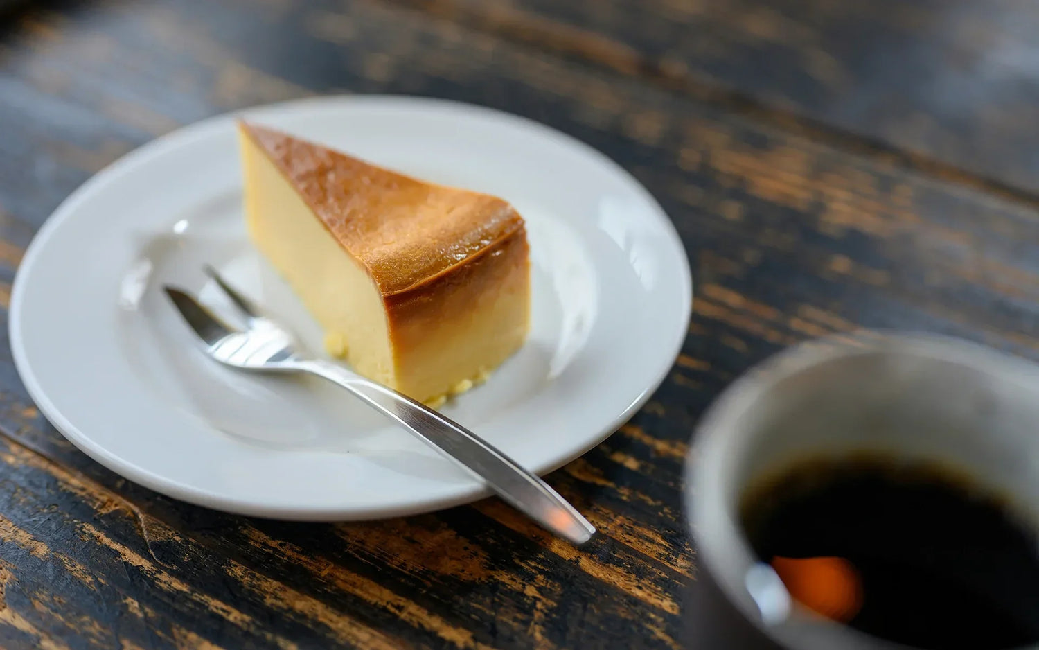 Topfenkuchen auf Dessertteller mit Gabel